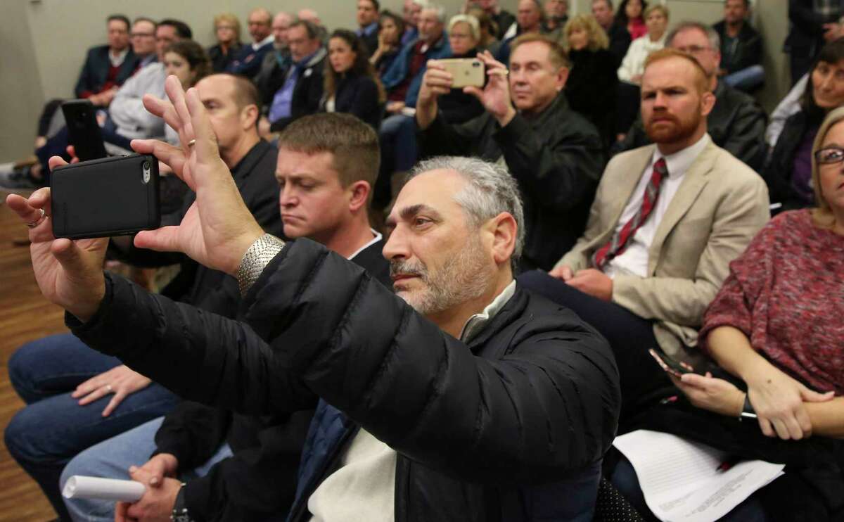 Lance Kassab, who owns a beach front home, takes a photograph of Texas A&M University at Galveston Marine Sciences professor William Merrell's ideas and suggestions for the "Ike Dike" concept with his cellphone during a special meeting hosted by the Galveston City Council members and mayor at the city council chamber on Thursday, Jan. 3, 2019, in Galveston. The Army Corps took Merrell's idea and expanded further to develop their proposal. The room was full of county residents and property owners, some had to sit at a overflow room. Feedback will be submitted to the Army Corps of Engineers.