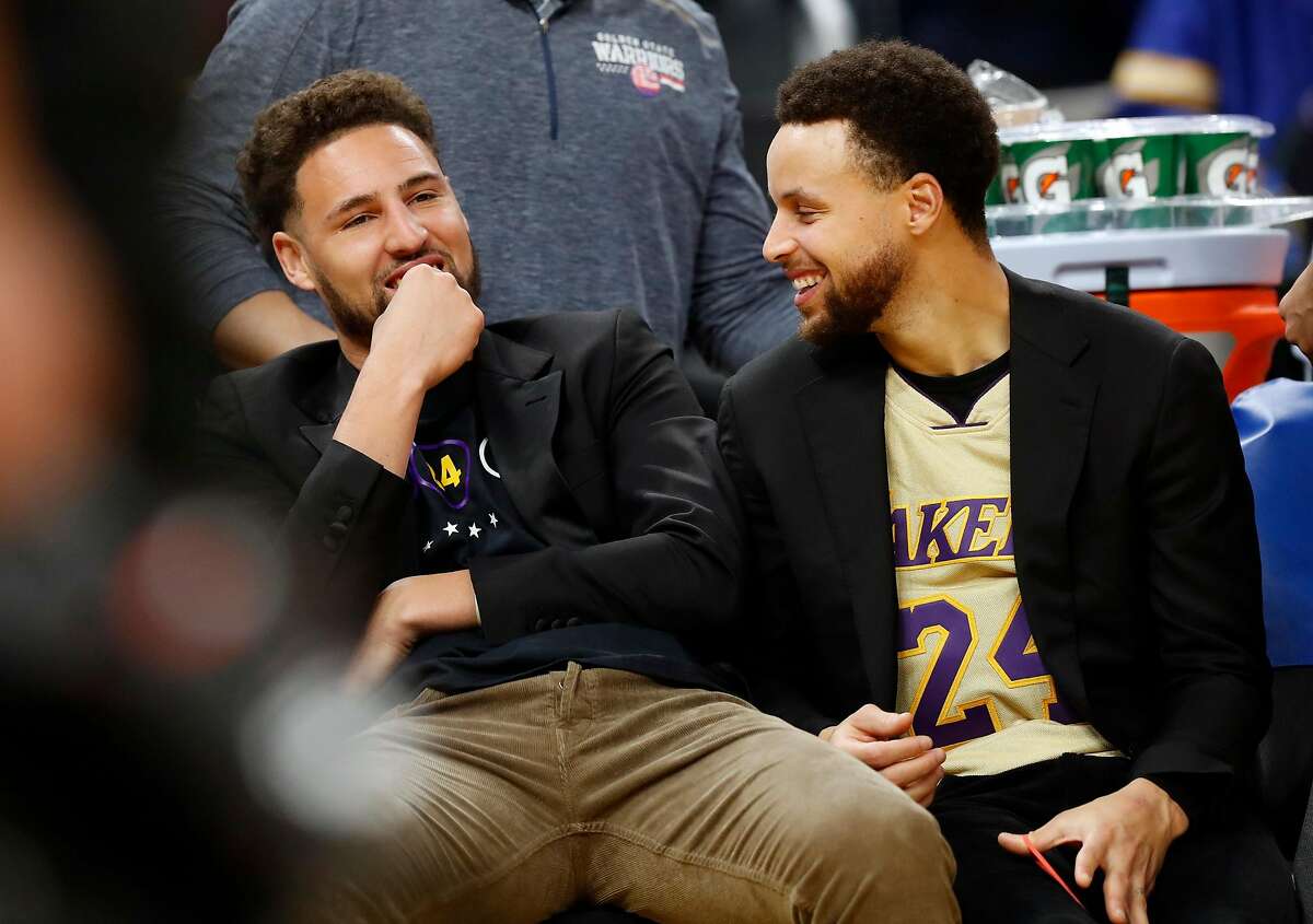 Golden State Warriors' Klay Thompson and Stephen Curry on bench during NBA game against Los Angeles Lakers at Chase Center in San Francisco, Calif., on Saturday, February 8, 2020.