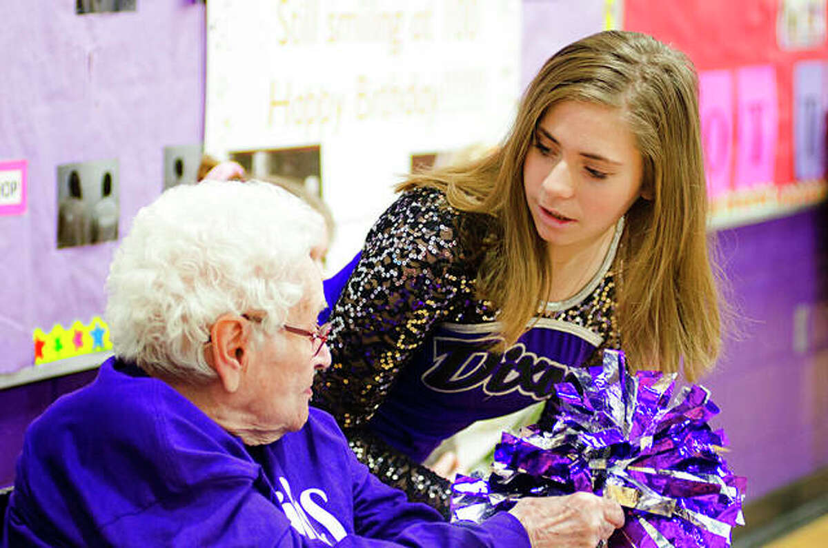 Addie Morley, 15, speaks with 100-year-old Mabel Green along the sidelines at Reagan Middle School while attending a Reagan Middle School basketball game. Green last took her place along the sidelines more than 80 years ago.