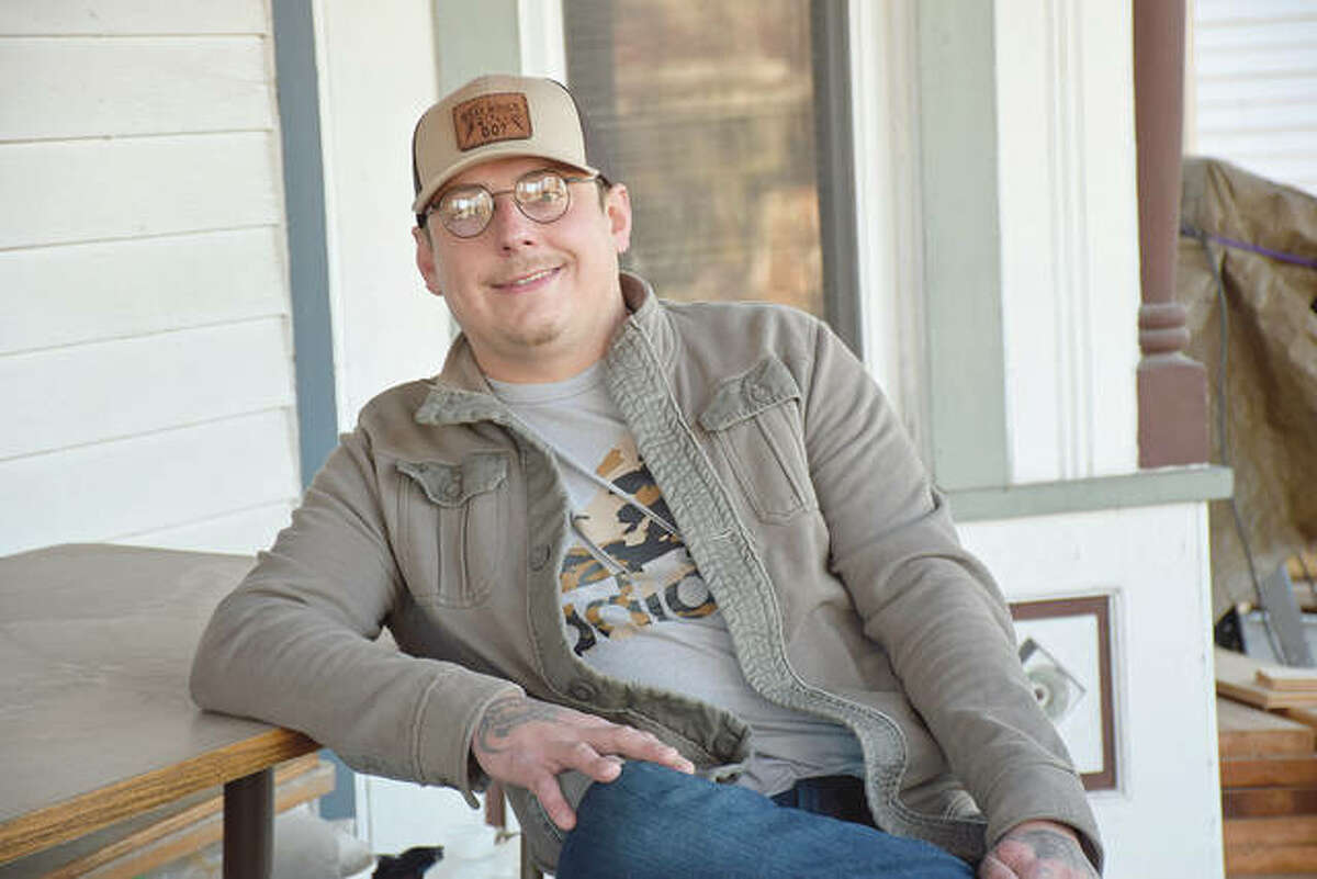 Richie Frederick sits on the porch of his home across from the Illinois School for the Deaf.