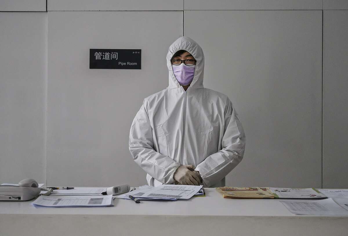 A Chinese worker wears a protective suit as he stands at the lobby desk of an office building while checking people entering on February 10, 2020 in Beijing, China. The number of cases of a deadly new coronavirus rose to more than 40000 in mainland China Monday, days after the World Health Organization (WHO) declared the outbreak a global public health emergency. China continued to lock down the city of Wuhan in an effort to contain the spread of the pneumonia-like disease which medicals experts have confirmed can be passed from human to human. In an unprecedented move, Chinese authorities have put travel restrictions on the city which is the epicentre of the virus and municipalities in other parts of the country affecting tens of millions of people. The number of those who have died from the virus in China climbed to over 900 on Monday, mostly in Hubei province, and cases have been reported in other countries including the United States, Canada, Australia, Japan, South Korea, India, the United Kingdom, Germany, France and several others. The World Health Organization has warned all governments to be on alert and screening has been stepped up at airports around the world. Some countries, including the United States, have put restrictions on Chinese travellers entering and advised their citizens against travel to China.