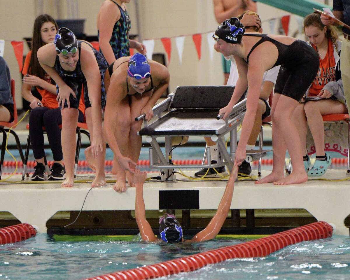 Kat Pashen of the Taylor Mustangs is welcomed by team mates Emma Clark, Emma Sticklen and Amy Evans after completing the last leg of the girls 200 yard medley relay during the District 19-6A Swimming and Diving Championships on January 18, 2020 at the Katy HS Natatorium, Katy, TX.