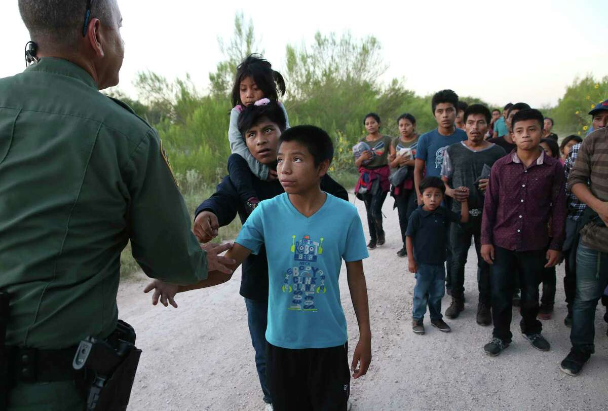 Migrants reach out to shake hands with U.S. Border Patrol Agent Carlos Ruiz as they turn themselves in after crossing the Rio Grande near the Anzalduas International Bridge in Hidalgo County in this July 2019. Photographer Jerry Lara, who’s been honored for his work, is “a stalwart of the department’s immigration coverage for the past decade,” says Luis Rios, director of photography at the Express-News.