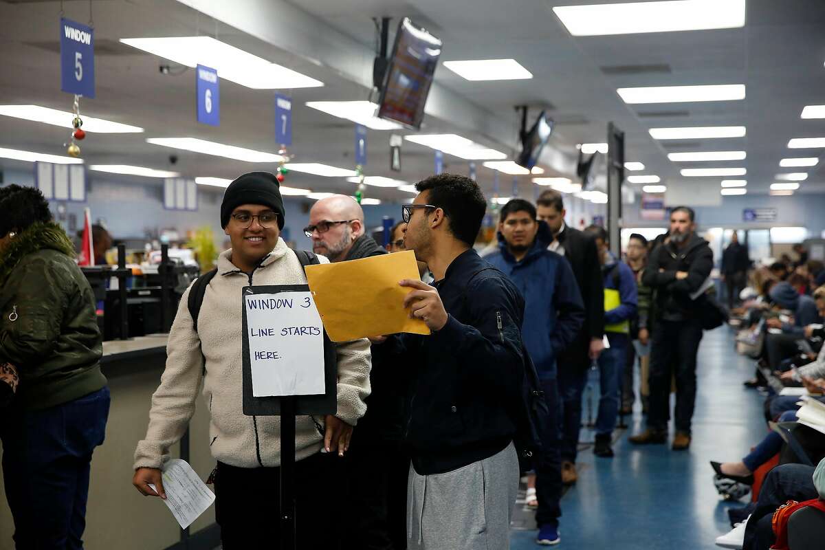 Elias Dubaie (l to r) of San Francisco talks with Kahlai Pratt of San Francisco as they wait in line to apply for the Real ID at the DMV on Fell Street on Friday, January 24, 2020 in San Francisco, Calif.