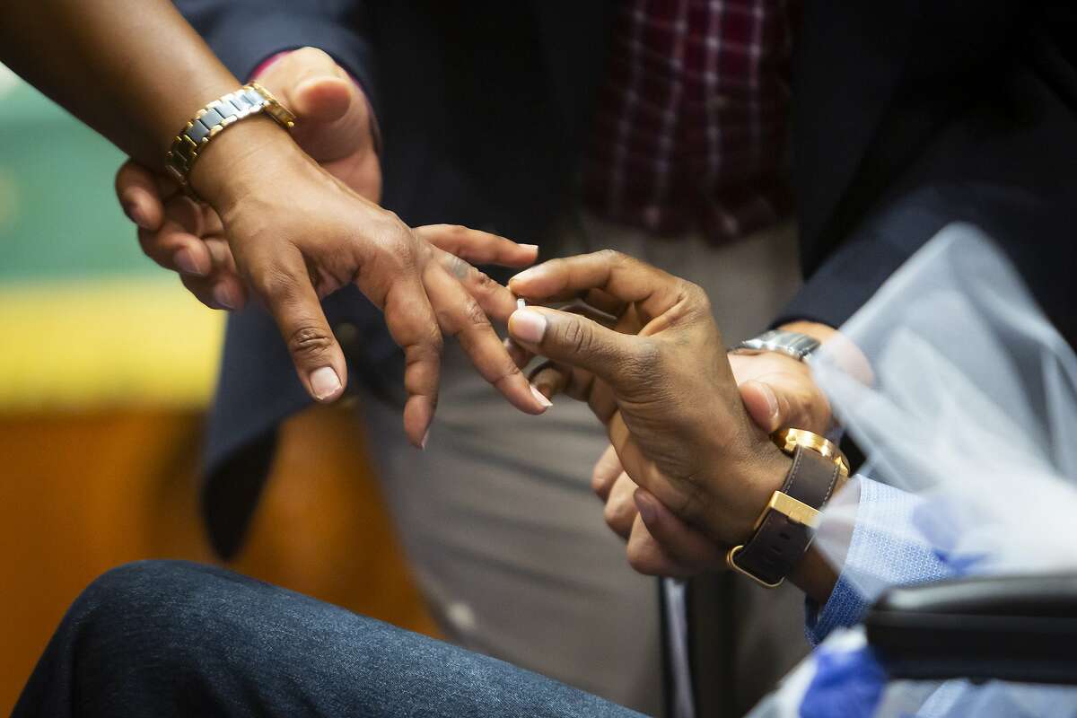 Tyyisha Marie Evans receives a ring from groom Corey Cunningham during their wedding ceremony in the Weiss Chapel at Houston Methodist Hospital on Monday, Feb. 10, 2020. In Nov. 2019, Cunningham was diagnosed with glioblastoma, an incurable brain cancer, just one month after Evans learned she was breast cancer free.