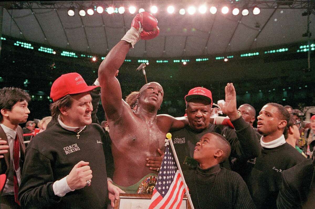 FILE - In this Feb. 11, 1990, file photo, heavyweight boxer James "Buster" Douglas waves his gloved hand to the cheering crowd as he makes his way to the dressing room following a 10th round knockout victory over Mike Tyson in a scheduled 12-round championship bout at the Tokyo Dome. In one of the more spectacular upsets in sports history, Douglas defeated Tyson, the reigning world heavyweight champion on Feb. 11, 1990, in Tokyo. (AP Photo/Sadayuki Mikami, File)