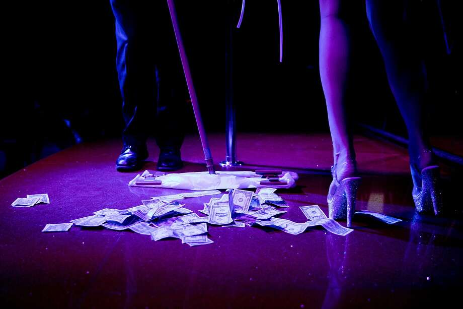 An attendant sweeps up tip money after Mia's performance on the main stage for patrons at the Condor Club in the North Beach neighborhood of San Francisco, Calif. Friday, February 7, 2020. Photo: Jessica Christian / The Chronicle