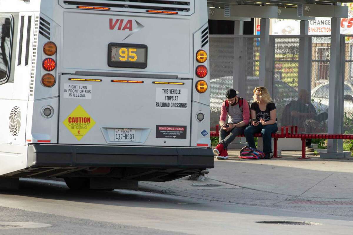 People wait for their bus at a VIA bus stop on Fredericksburg Road last week.