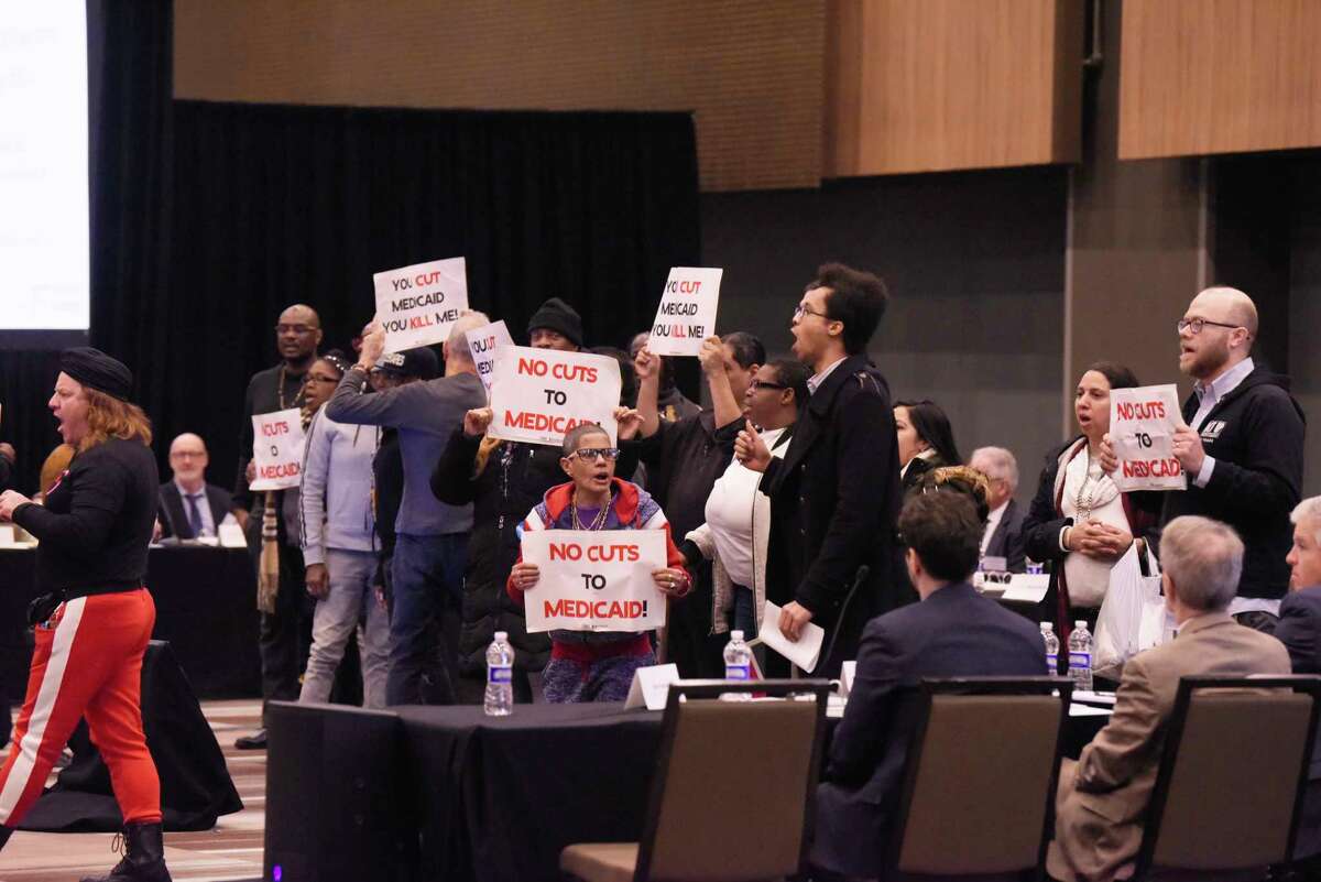 Protesters disrupt the first meeting of the Medicaid redesign team at the Albany Capital Center on Tuesday, Feb. 11, 2020, in Albany, N.Y. The protesters were ultimately escorted out of the meeting. (Paul Buckowski/Times Union)