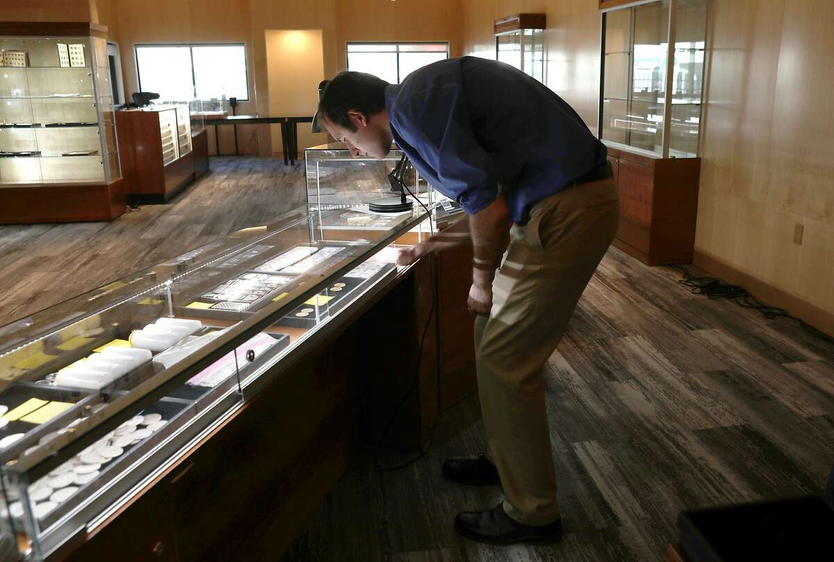 Sales manager James Andrews views coins at Witter Coins located in the old International House of Pancakes on Monday, Feb. 10, 2020, in San Francisco, Calif.