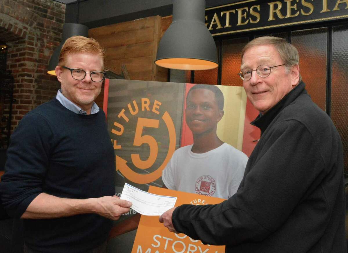 Gates Restaurant Owner Jay Luther presents a check to longtime New Canaan resident and Future 5 Founder Clif McFeely.