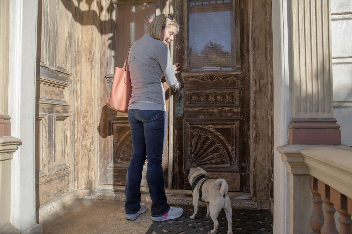 Leah Culver enters the front door of her recently purchased Painted Lady house on Steiner Street near Alamo Square in San Francisco with her dog Mr. Wiggles. The interior needs major renovations, and she is sharing her project to fix up the iconic victorian home on her Instagram @pinkpaintedlady.