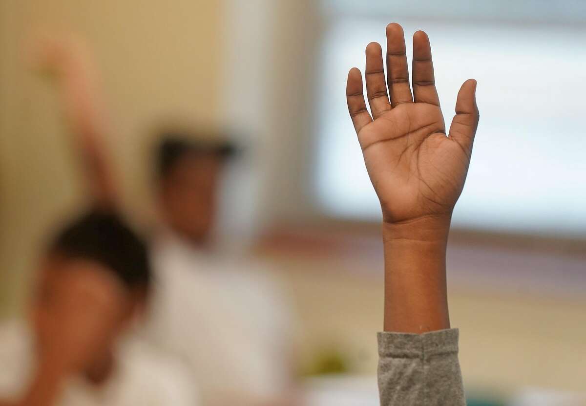 Students raise their hands to answer questions during classes at the Dallas ISD's Umphrey Lee Elementary School, one of the district's signature turnaround schools involved in the improvement initiative known as ACE.