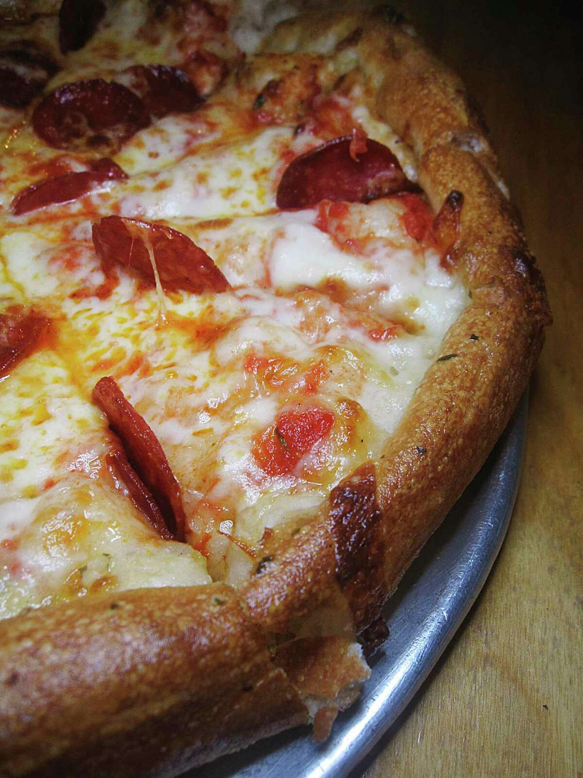 A pepperoni pizza is served on a crust infused with garlic and herbs at Tank's Pizza.