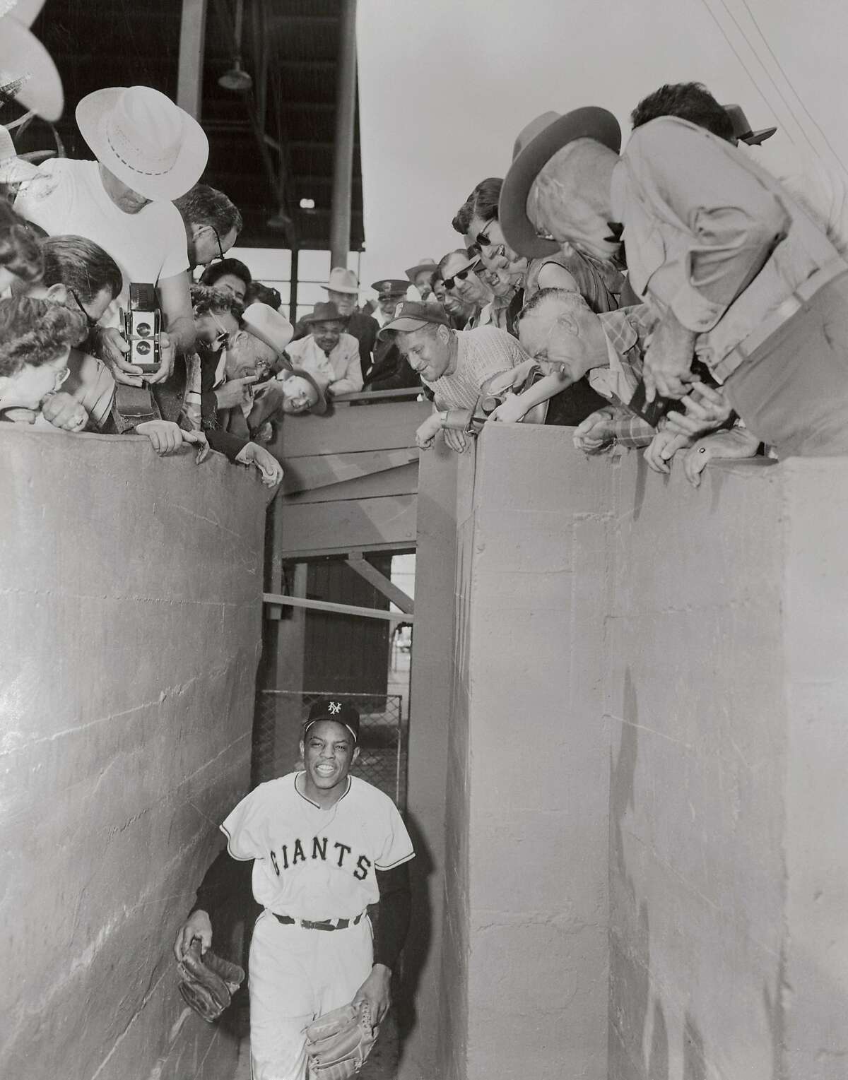 (Original Caption) Fans at New York Giants spring training camp watch Willie Mays as he comes from the locker room in this photo.