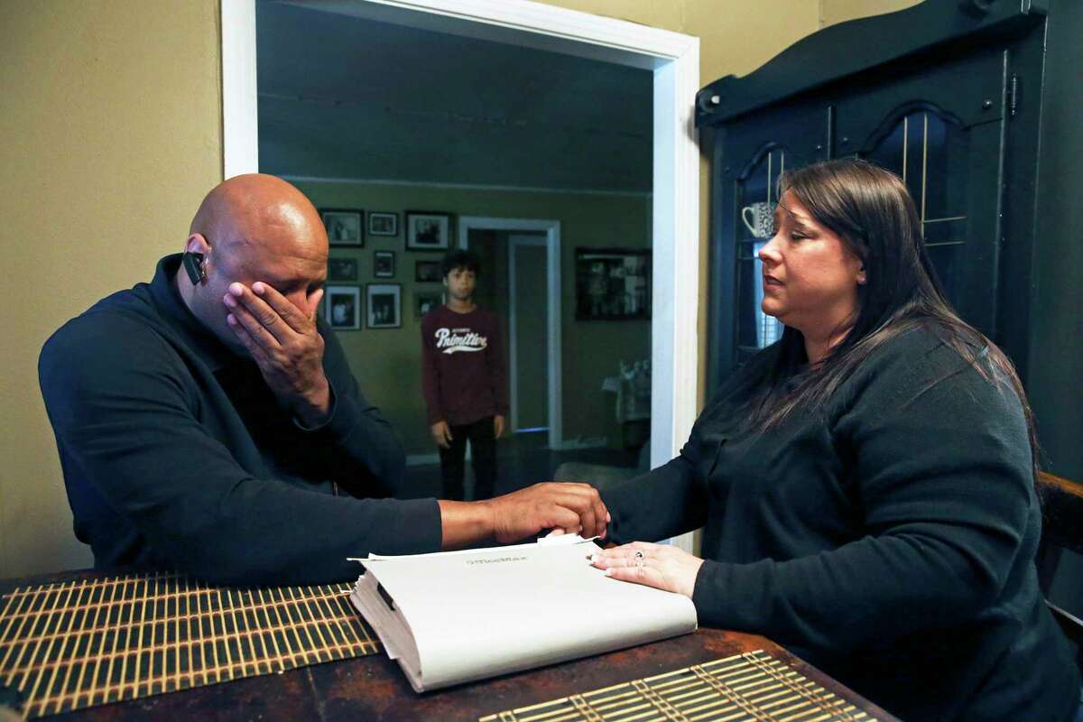 Hearing the distress of his parents, son Nathan, 14, approaches in the background as Ron and Ann Jones anguish in dealing with the massive headache of paperwork and worries on Feb. 6, 2020 after hiring Synergy, a company offering loan modification services.
