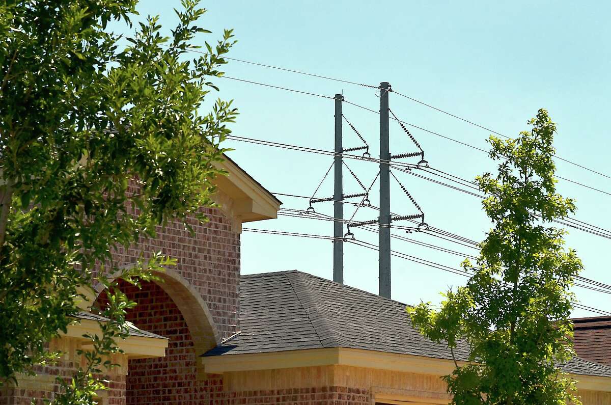 Power lines that provide electricity to the Shiloh Subdivision can be seen behind a home in the Shiloh Subdivision Wednesday afternoon. The Electric Reliability Council of Texas (ERCOT) called for Texas residents to conserve energy to avoid blackouts as temperatures rise over the century mark.