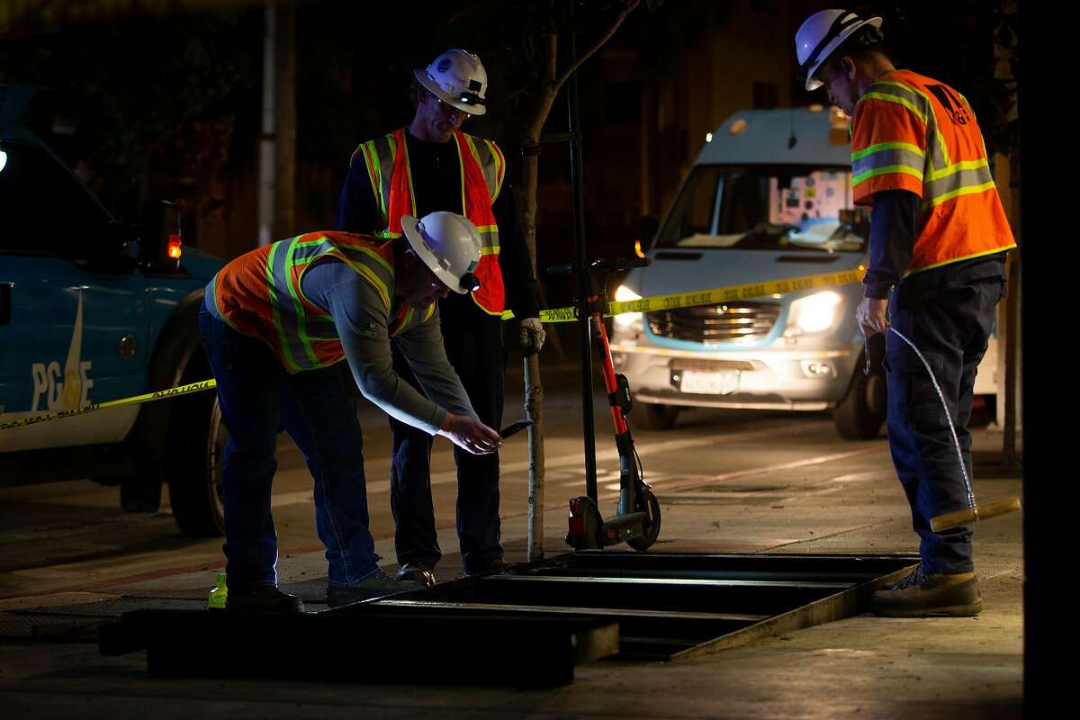 PG&E emergency crews look at underground equipment at the corner of Hayes Street and Laguna Street after an underground electrical transformer reportedly exploded causing an outage in the nearby neighborhood in San Francisco, Calif. on Wednesday, Feb. 12, 2020.