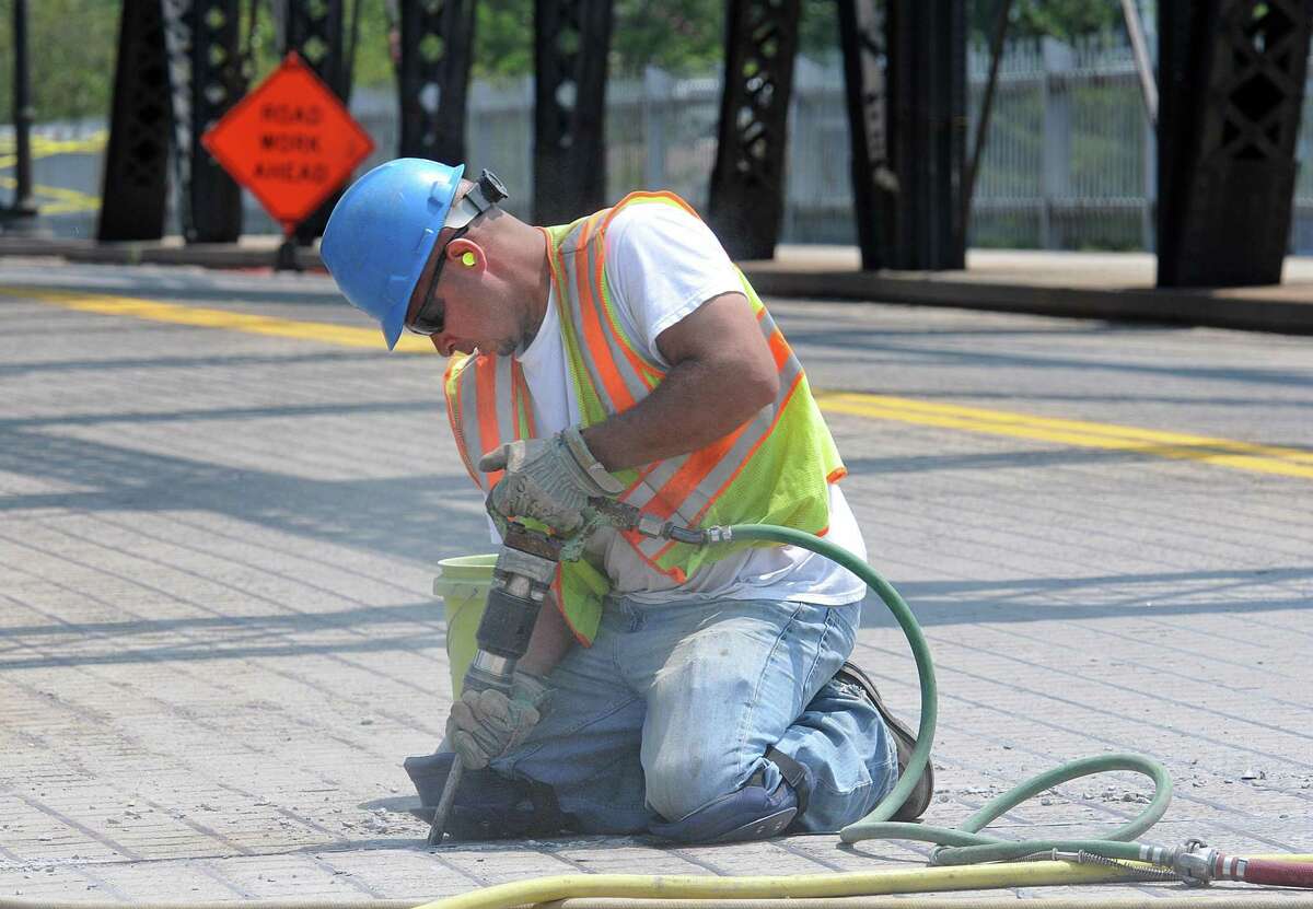 In this file photo, Sonny Jimenez of Blakeslee Arpaia Chapman Inc (Branford) uses a jackhammer as workers try to fix the Grand Avenue bridge. The bridge has been stuck due to the recent heat wave, which has expanded the metal and frozen the bridge closed. Photo-Peter Casolino/New Haven Register Cas110720 7/20/11
