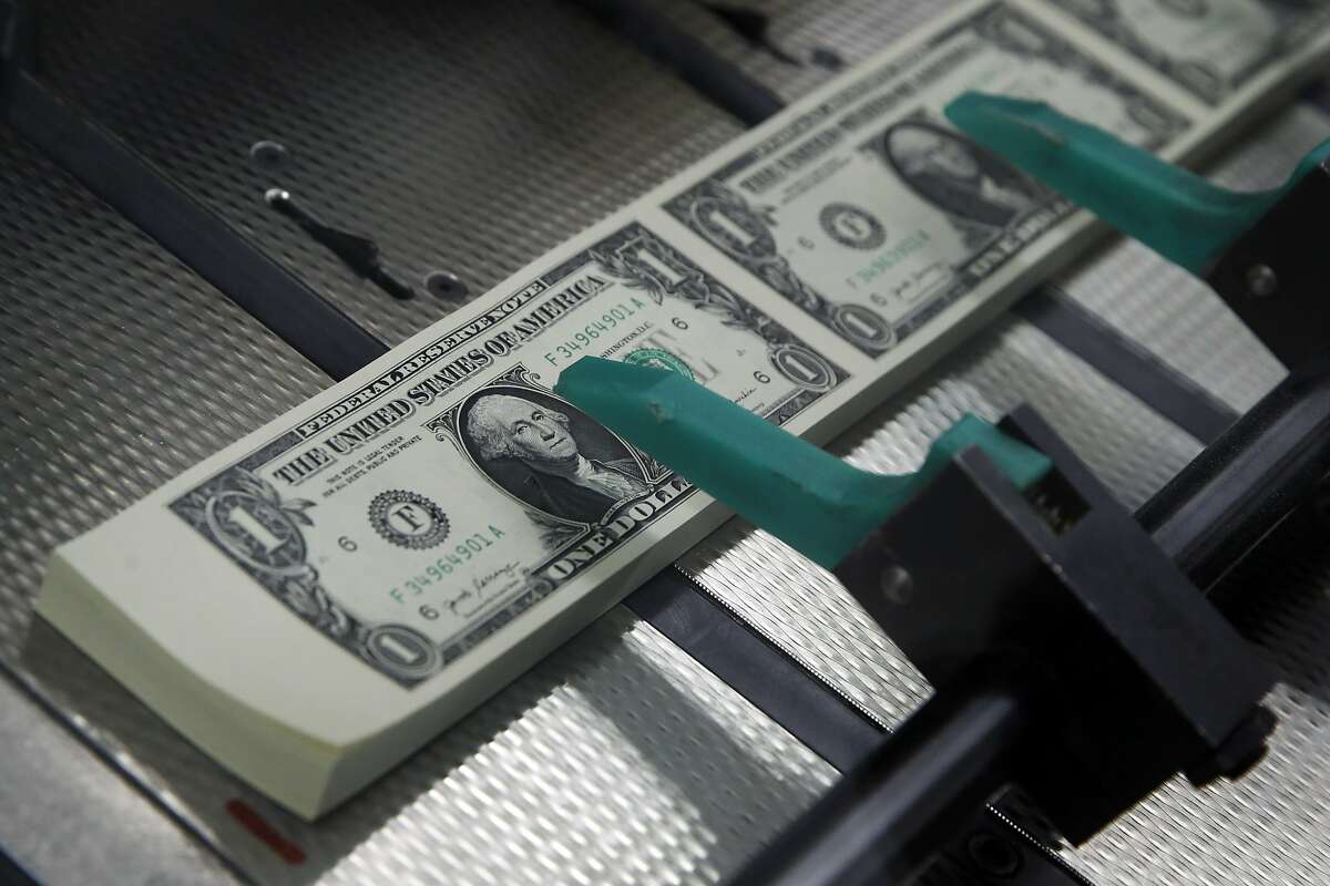 FILE- In this Nov. 15, 2017, file photo, new $1 bills with the signatures of U.S. Treasurer Jovita Carranza and Treasury Secretary Steven Mnuchin are cut and stacked at the Bureau of Engraving and Printing in Washington. Fidelity Investments says the average 401(k) balance rose to a record $112,300 last year. Part of the gain was due to surging markets, as stocks and bonds of all types rallied. (AP Photo/Jacquelyn Martin, File)