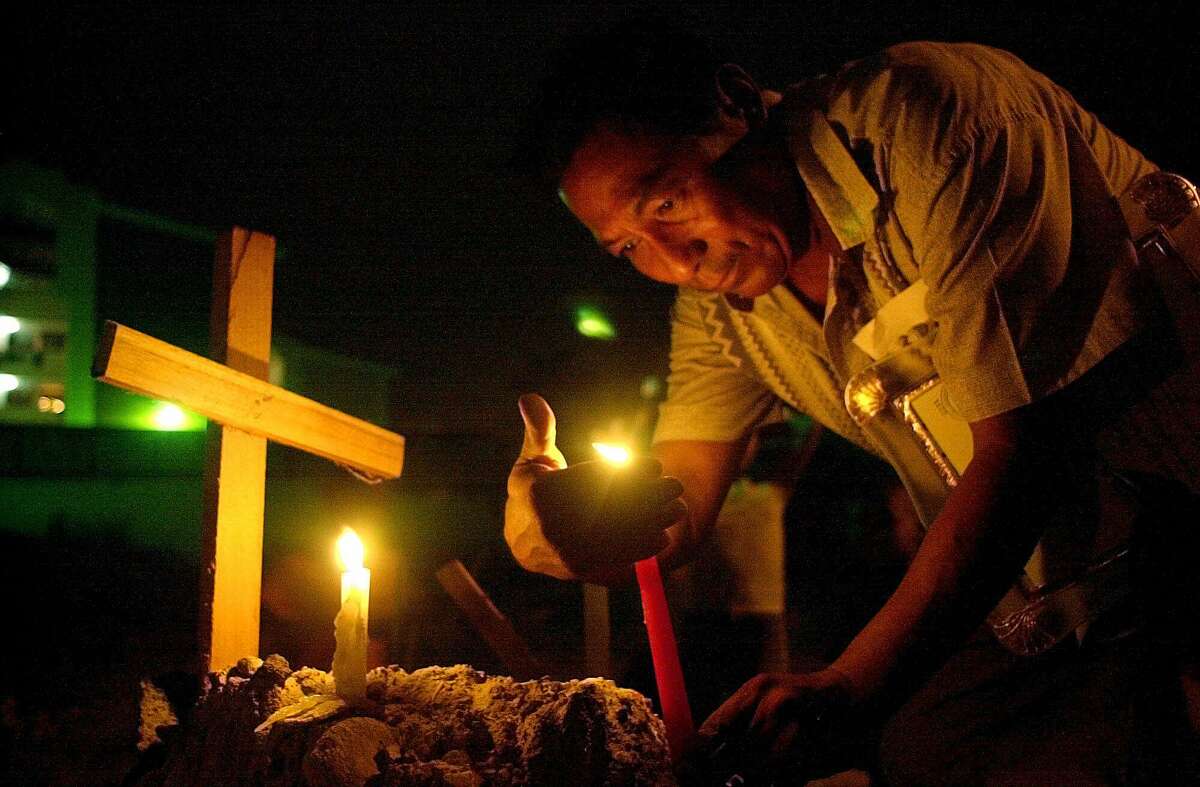 Ruben Dario Camargo lights a candle to mark the 11th anniversary of the U.S. military invasion in El Chorrillo, Panama City, Wednesday, Dec. 20, 2000. The invasion on Dec. 20, 1989, successfully removed dictator Manuel Noriega from power but at least 400 Panamanians died in the attack. Human rights groups give estimates that run into the thousands. About 20 American troops also died.