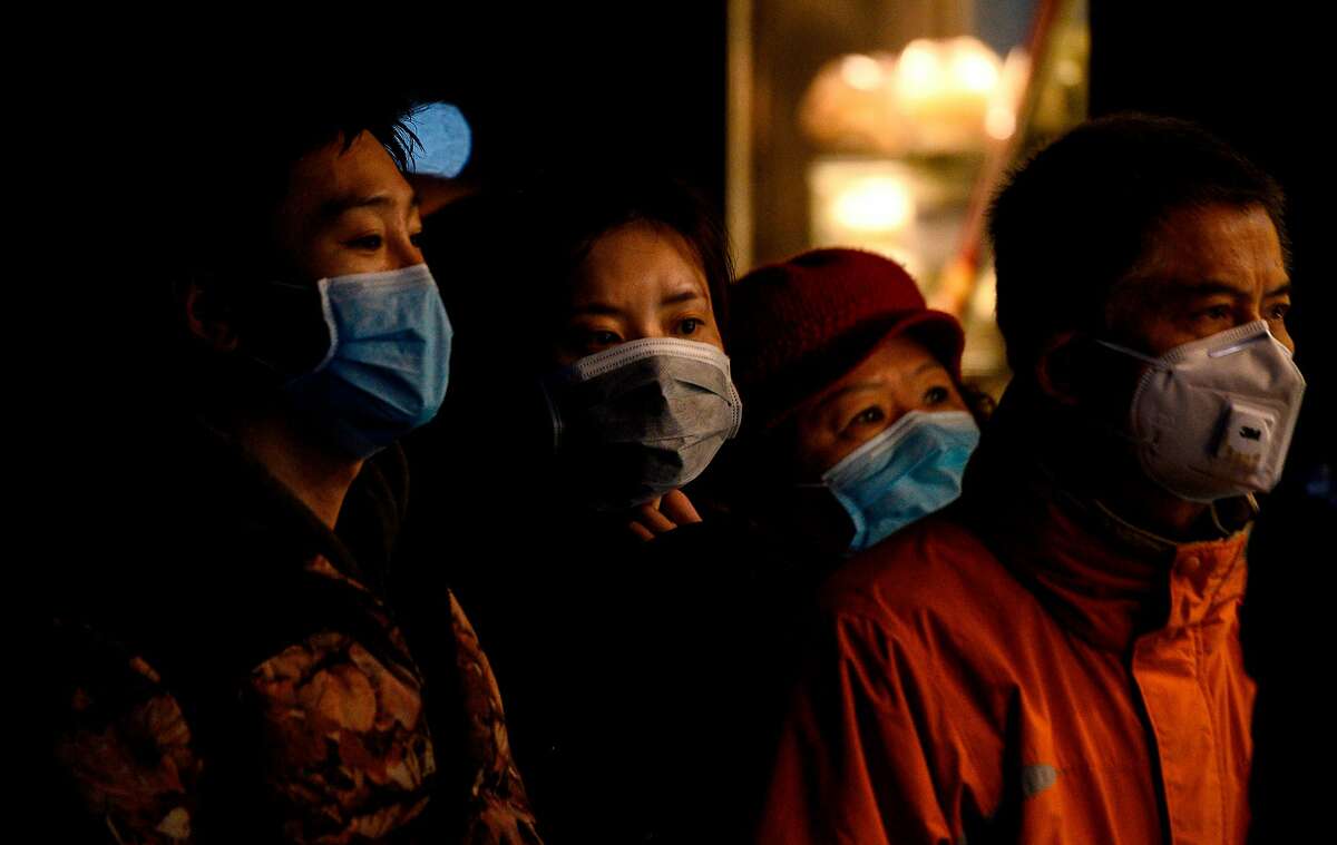 People wearing protective facemasks queue to order food from a stall in Shanghai on February 14, 2020. - Youan Hospital is one of twenty hospitals in Beijing treating coronavirus patients. Six health workers have died from the COVID-19 coronavirus in China and more than 1,700 have been infected, health officials said on February 14, underscoring the risks doctors and nurses have taken due to shortages of protective gear.