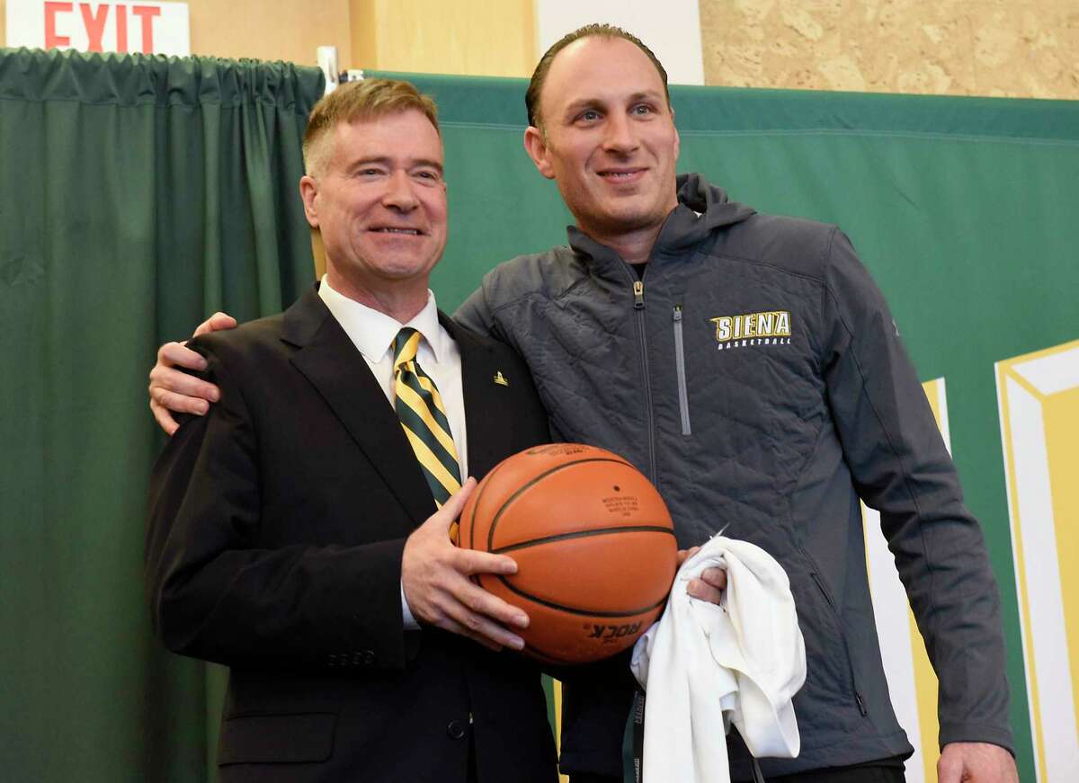 Carmen Maciariello, head coach men's basketball team, gives former U.S. Rep. Chris Gibson gifts as Siena College announces him as its 12th president at Siena College on Friday, Feb. 14, 2020 in Loudonville, N.Y. Gibson, Ph.D, graduated from Siena in the class of '86. (Lori Van Buren/Times Union)