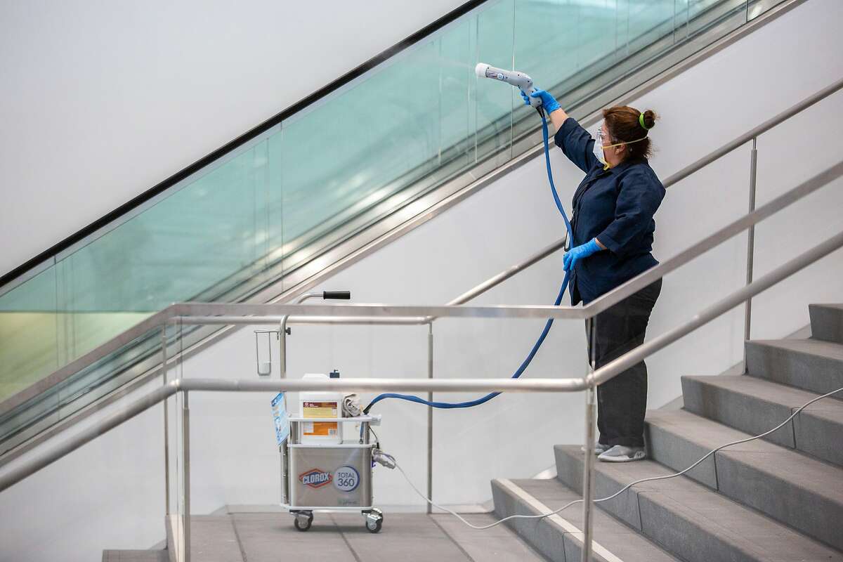 Evelin Rivera uses an electrostatic cleaner at Moscone Center South, Friday, Feb. 14, 2020, in San Francisco, Calif.
