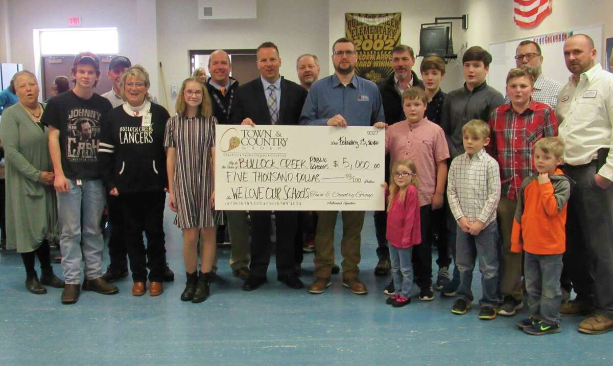 Representatives of the Town & County Group visited Bullock Creek Elementary School on Thursday to present a $5,000 check to pay off the school's lunch account deficit. (Mitchell Kukulka/Mitchell.Kukulka@mdn.net)