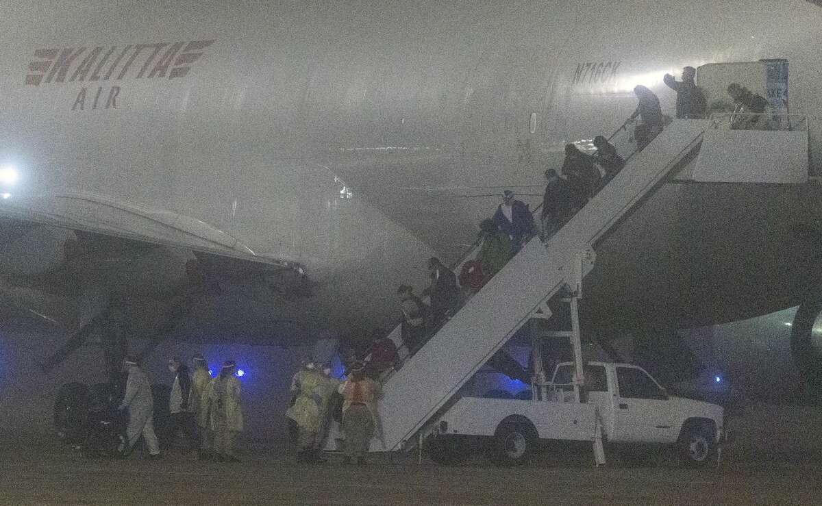 American passengers evacuated from a cruise ship in Japan disembark Monday morning, Feb. 17, 2020 from a Kalitta Air flight at Kelly Field. The passengers had been quarantined on the cruise ship as part of coronavirus control measures.