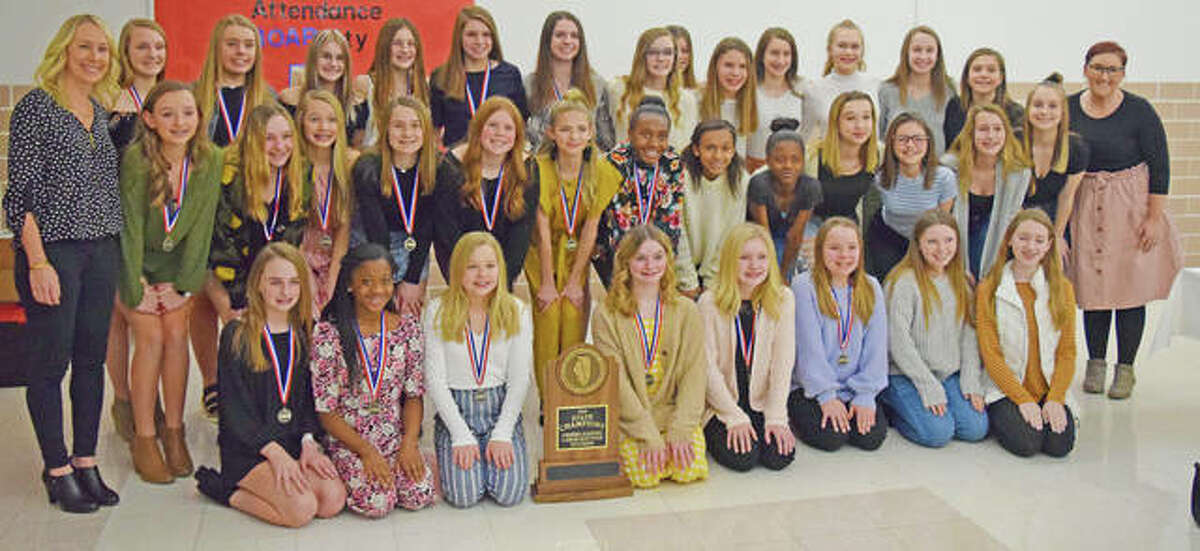 Cheerleaders from both Liberty Middle School and Lincoln Middle School and their coaches pose with their medals and trophy after being recognized by the District 7 School Board Monday night.