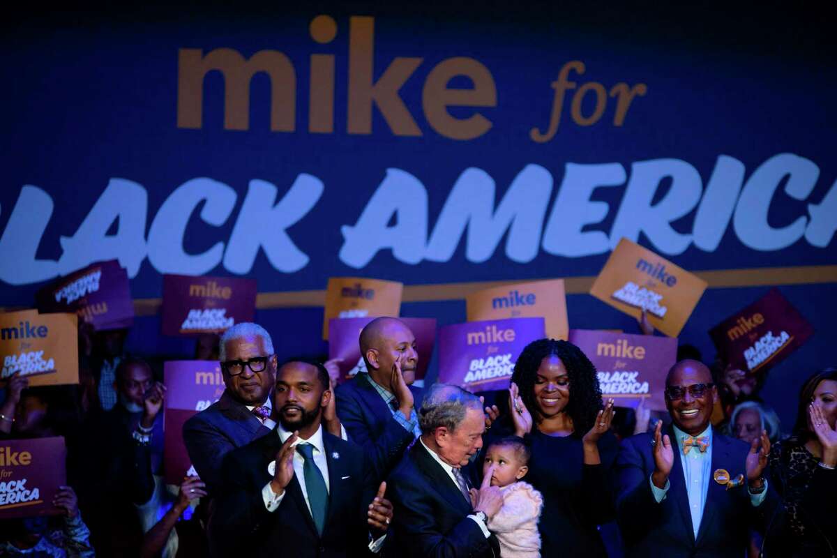 TOPSHOT - Democratic presidential hopeful Mike Bloomberg (C) holds a baby during the "Mike for Black America Launch Celebration" at the Buffalo Soldier National Museum in Houston, Texas, on February 13, 2020. (Photo by Mark Felix / AFP) (Photo by MARK FELIX/AFP /AFP via Getty Images)