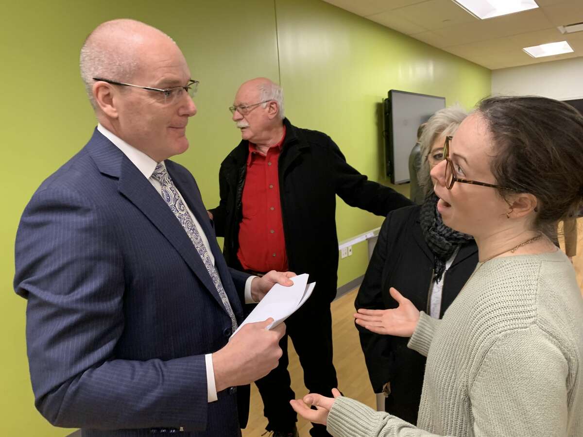 Melanie O'Malley, right, a business owner affected by MyPayrollHR's collapse, speaks with Pioneer Bank CEO Tom Amell during the company's annual shareholder meeting on Tuesday, Feb. 18, 2020.