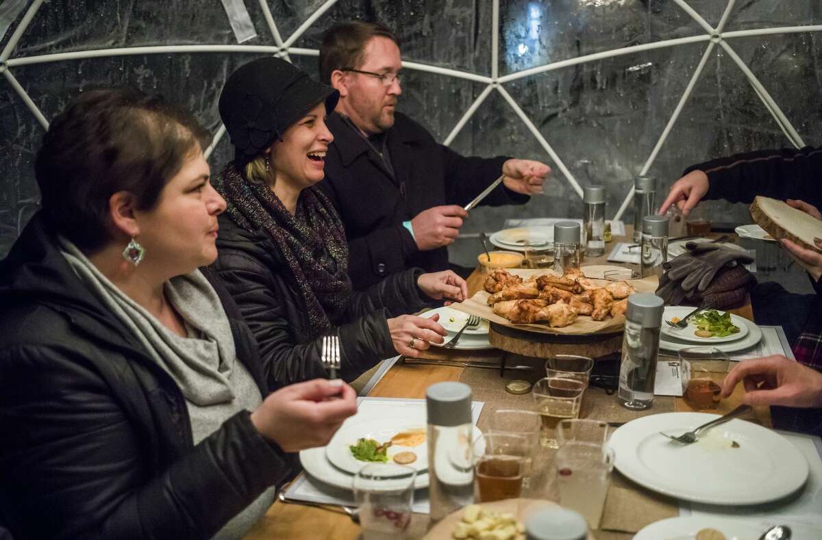 From left, Olivia Vanderleij, Sarah Hocking and David Hocking enjoy an eight-course meal with a group of friends inside a heated igloo tent during the Eat Great Winter event, hosted by Octagon, Monday, Feb. 17, 2020 at Dow Gardens. (Katy Kildee/kkildee@mdn.net)