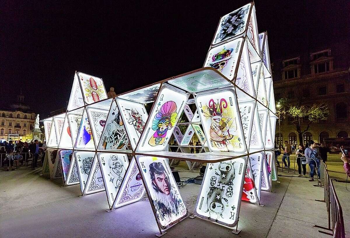 The exhibit features life-size playing cards that display works from 20 local artists and is illuminated at night with choreographed lights.
