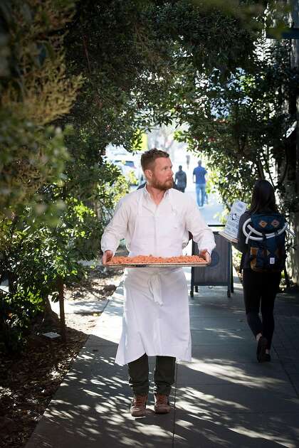 Chef Thomas McNaughton carries a tray of pasta from Flour + Water restaurant down the street to Central Kitchen restaurant. Both restaurants are part of the Ne Timeas Restaurant Group, which McNaughton and partners founded.