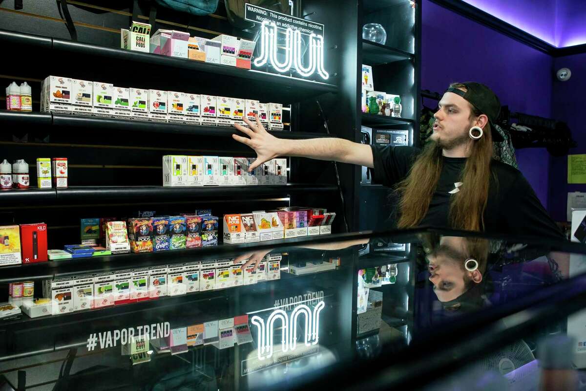 Vapor Trend Vape & CBD Shop manager Ty Marceaux points out the remaining inventory of flavored e-cigarette cartridges, the ones that the federal government is banning citing their popularity with teenagers, at the store along the Katy Freeway in Houston, Monday, Jan. 6, 2020. The pods go into small e-cigarettes like the ones manufactured by the company Juul. Other vape products, like ones that feature their own refillable tanks, are not impacted by the federal ban that starts in the next month.