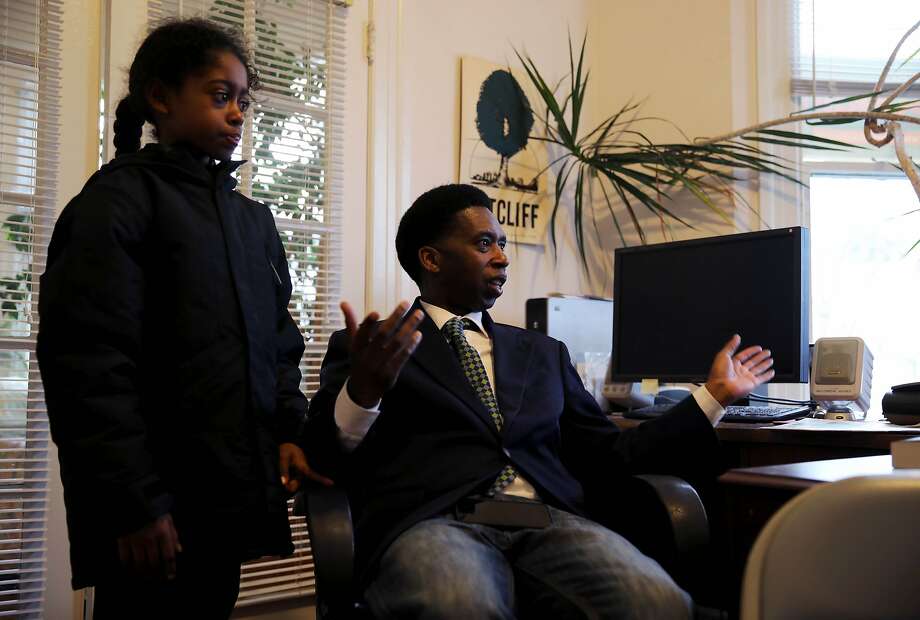 Kamari Epps, 9, stands beside his father, San Francisco documentary filmmaker Kevin Epps, right, as he speaks with Dr. Willie Ratcliff, publisher, San Francisco Bay View, in Ratcliff's office in San Francisco, Calif., on Wednesday, January 8, 2020. Epps was held to answer on murder and other charges last month in San Francisco Superior Court after a star witness for the prosecution recounted the details of what happened during a fatal shooting inside a Diamond Heights apartment in 2016. Epps is out on bail after a judge determined he was not a threat to the community and his case is being closely watched by advocates, especially in Bayview Hunters Point where Epps grew up. Photo: Yalonda M. James / The Chronicle