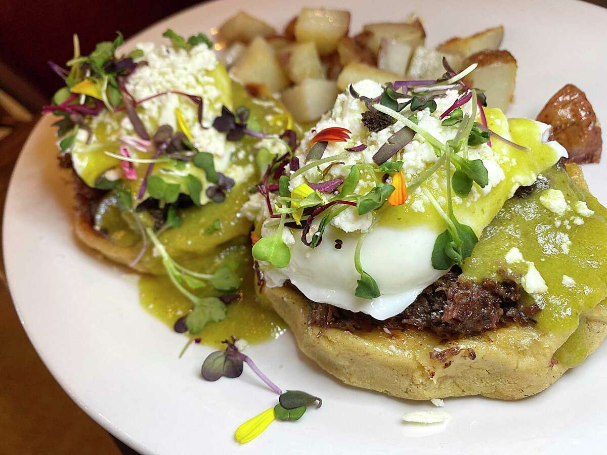 Mexican Benedicts include barbacoa, poached eggs, green chile hollandaise, queso fresco and cilantro on handmade corn sopes with a side of rosemary potatoes at Marla Restaurant.
