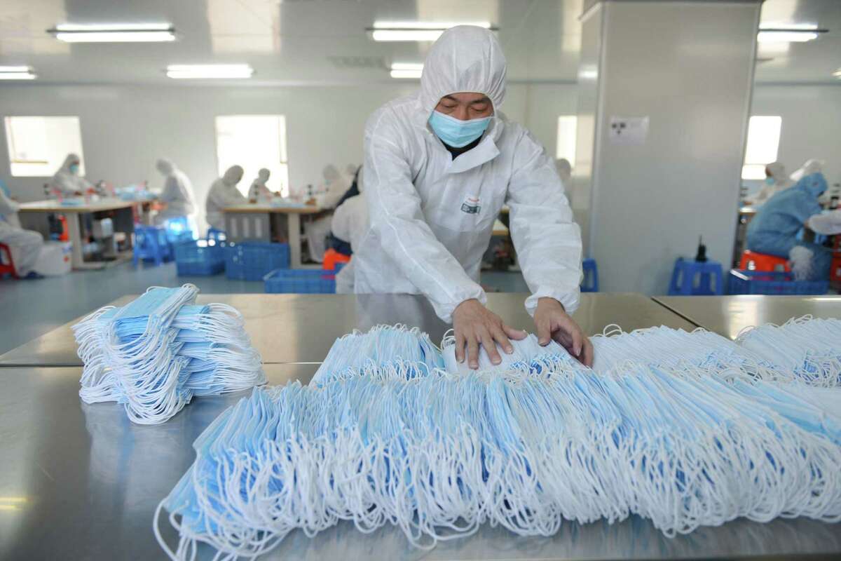 This photo taken on February 18, 2020 shows a worker sorting face masks being produced to satisfy increased demand during China's COVID-19 coronavirus outbreak, at a factory in Nanjing, in China's Jiangsu province. - The medical equipment factory switched surgical instruments and dental equipment production lines to a mask production line to meet the increased demand. (Photo by STR / AFP) / China OUT (Photo by STR/AFP via Getty Images)