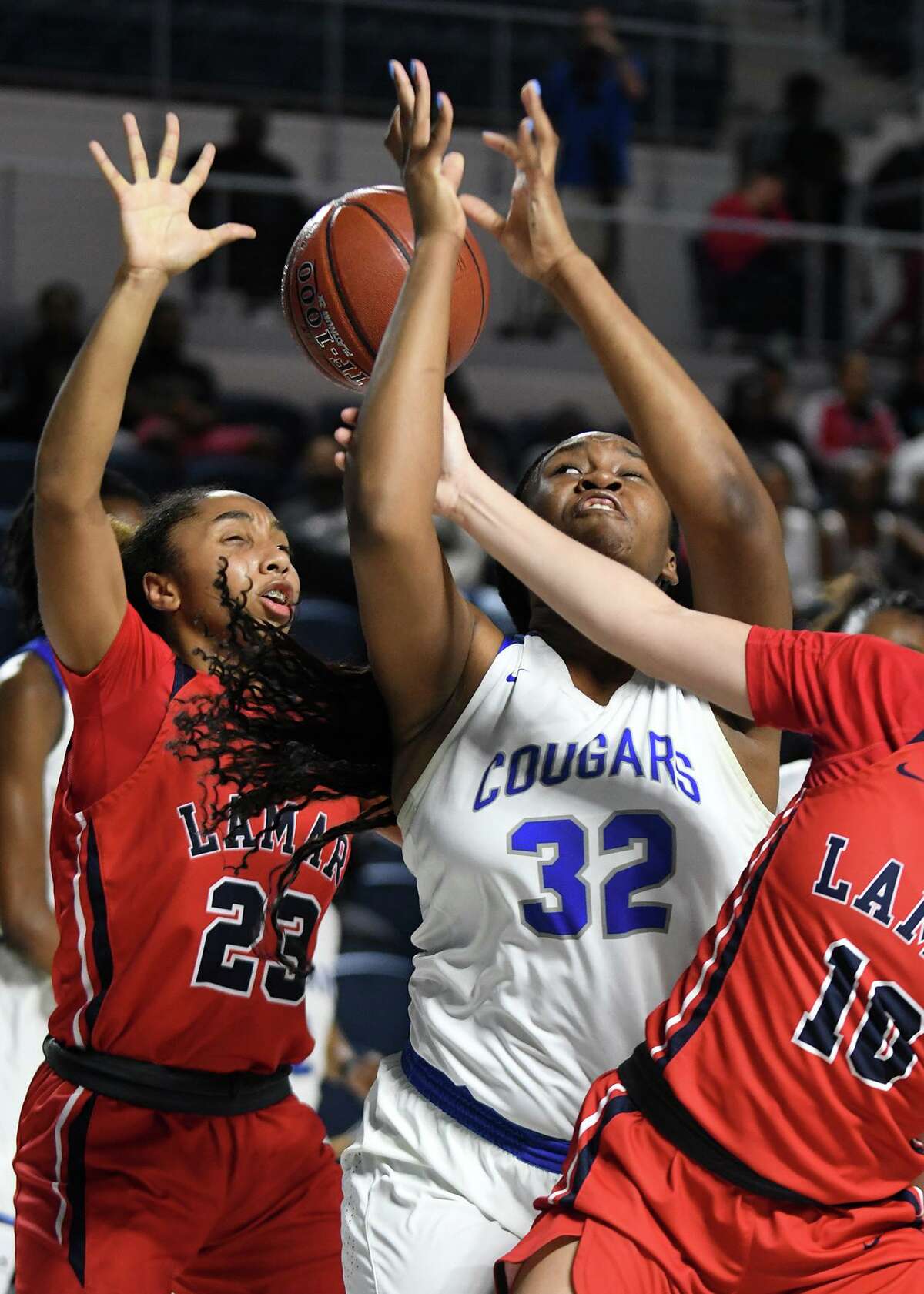 Cy Creek junior center Taylor Jackson (32) battles for a rebound against Lamar's Shani Darkins (23) and Halie Basquine (10) during the 2nd quarter of their Region III-6A UIL Girls Basketball Bi-District playoff matchup at Delmar Fieldhouse in Houston on Feb. 17, 2020