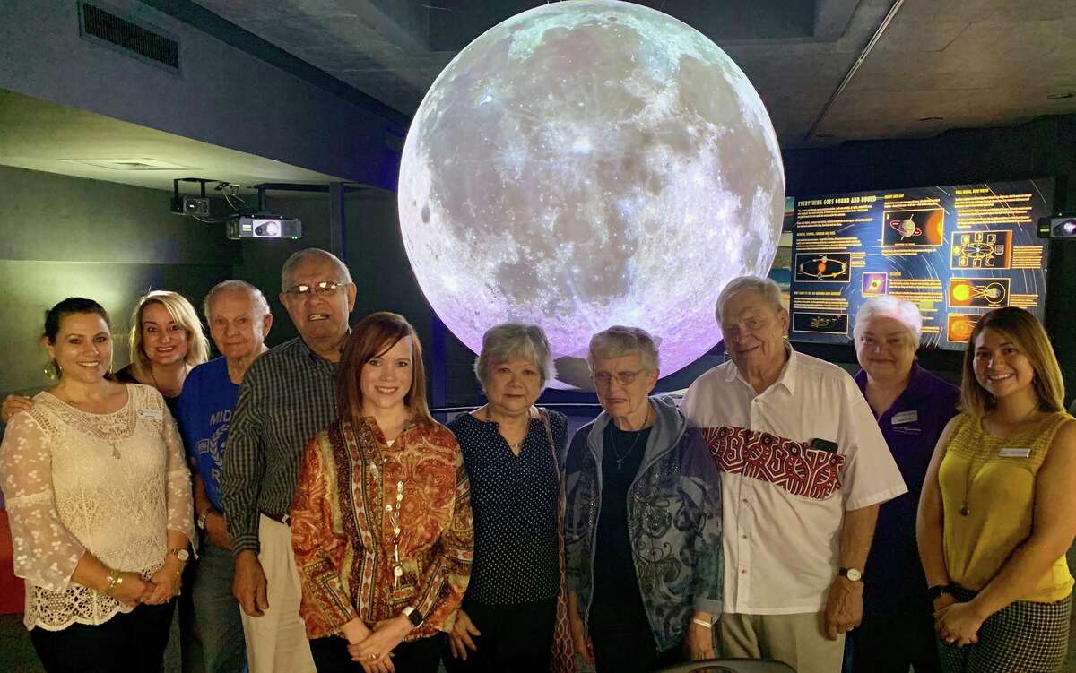 Tracy Renton and Kathleen Kirwan-Haynie, far left, stand with RSVP volunteers and Museum of the Southwest staff in an outing to Science on a Sphere.
