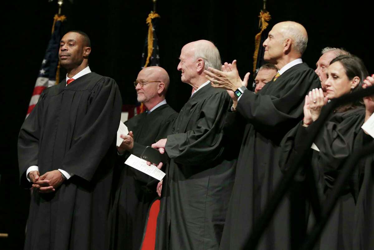 Jason K. Pulliam, the first African-American appointed as a federal judge in the U.S. District Court’s Western District of Texas, formally takes the oath of office and stands among his peers during an investiture ceremony at the Lila Cockrell Theater on Thursday.