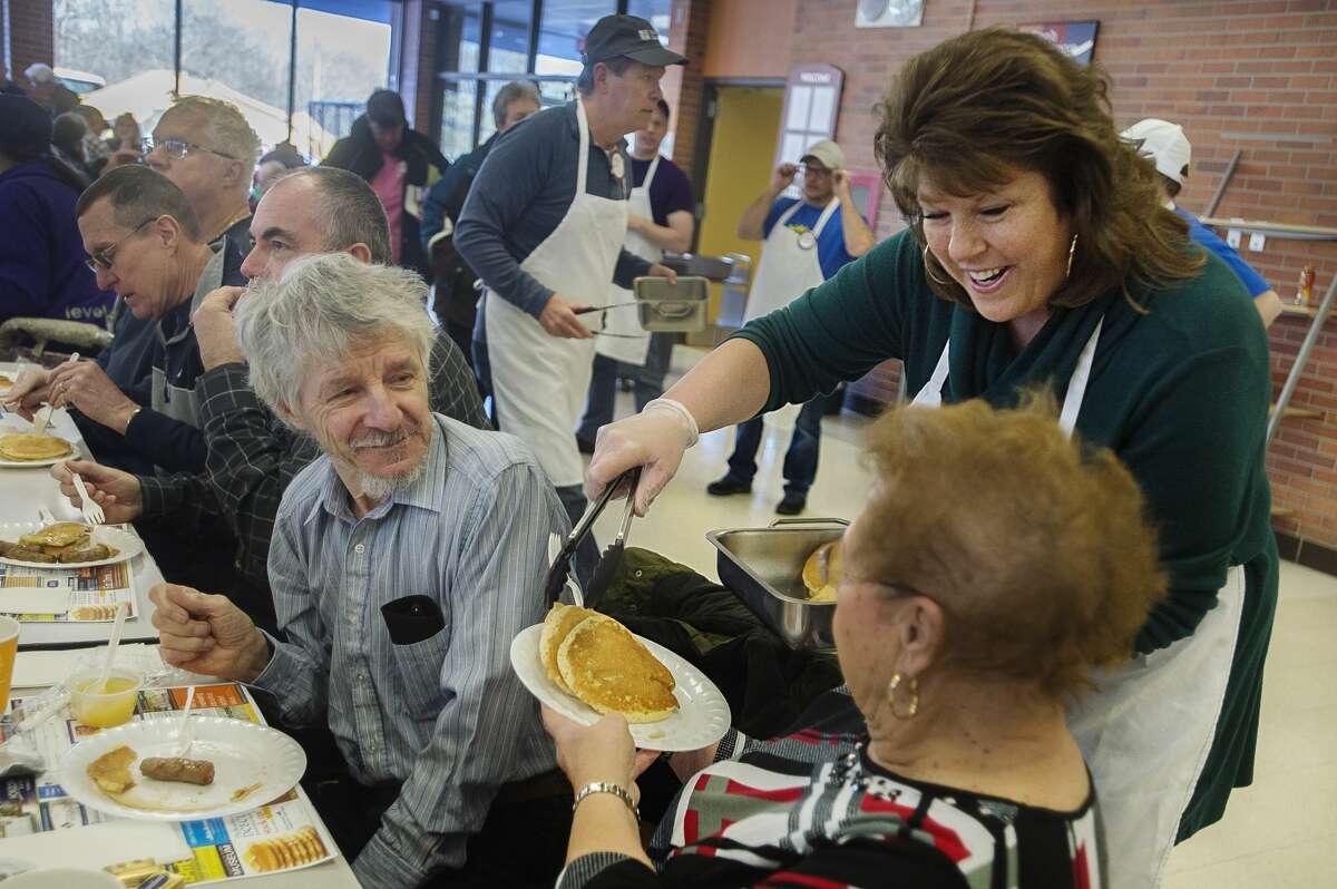 Angela Cole, right, serves pancakes to Mary Kay Brandt, bottom, and David Flock, left, during the annual Rotary Pancake Supper Thursday, Feb. 20, 2020 at H. H. Dow High School. (Katy Kildee/kkildee@mdn.net)