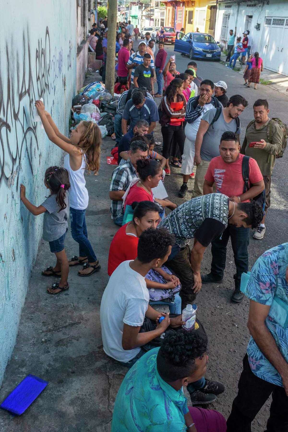 Here migrants line up outside the offices of COMAR (Comisión Mexicana de Ayuda a Refugiados) in Tapachula in hopes of receiving a visa that will let them remain in Mexico legally.