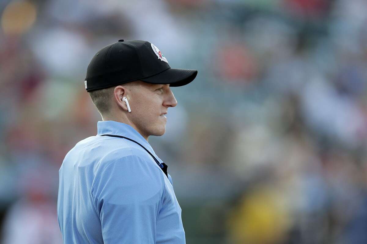 Home plate umpire Brian deBrauwere looks on while wearing an earpiece connected to a ball and strikes calling system prior to the start of the Atlantic League All-Star minor league baseball game, Wednesday, July 10, 2019, in York, Pa. deBrauwere wore the earpiece connected to an iPhone in his ball bag which relayed ball and strike calls upon receiving it from a TrackMan computer system that uses Doppler radar. The independent Atlantic League became the first American professional baseball league to let the computer call balls and strikes during the all star game.