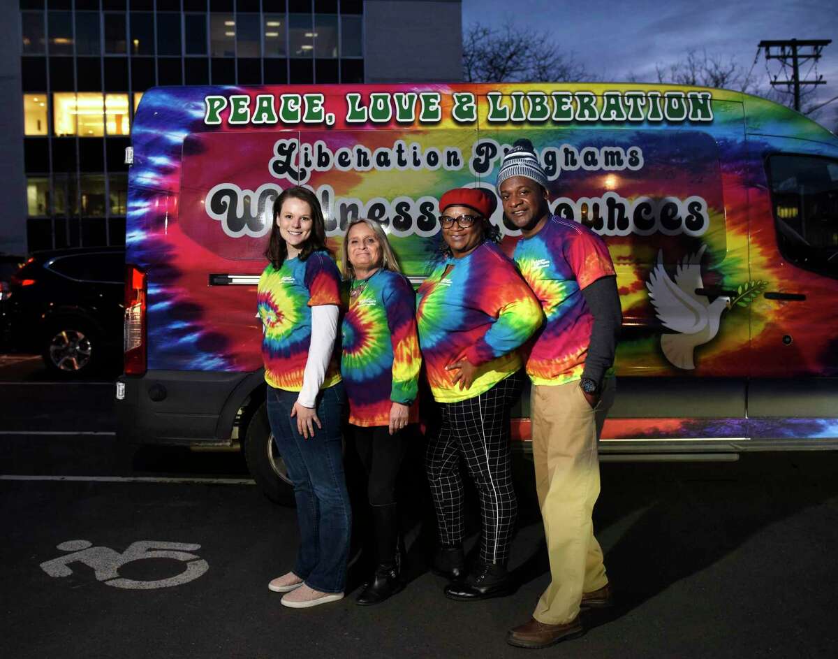 From left, Liberation Programs employees in front of the Mobile Wellness Van in the parking lot at the YMCA in Greenwich on Tuesday. They provide on-the-street services to those struggling with opiates.