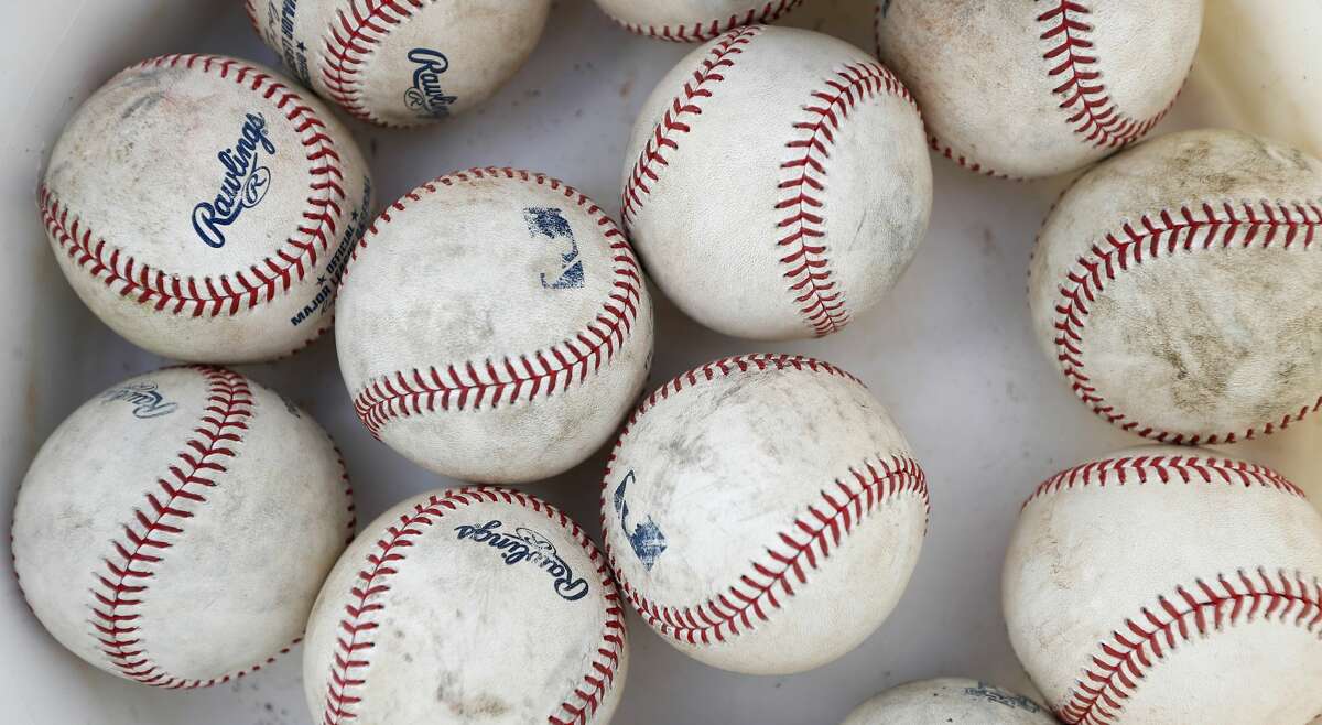 Scuffed up baseballs in a bucket during spring training at the Fitteam Ballpark of The Palm Beaches, in West Palm Beach, Saturday, Feb. 22, 2020.