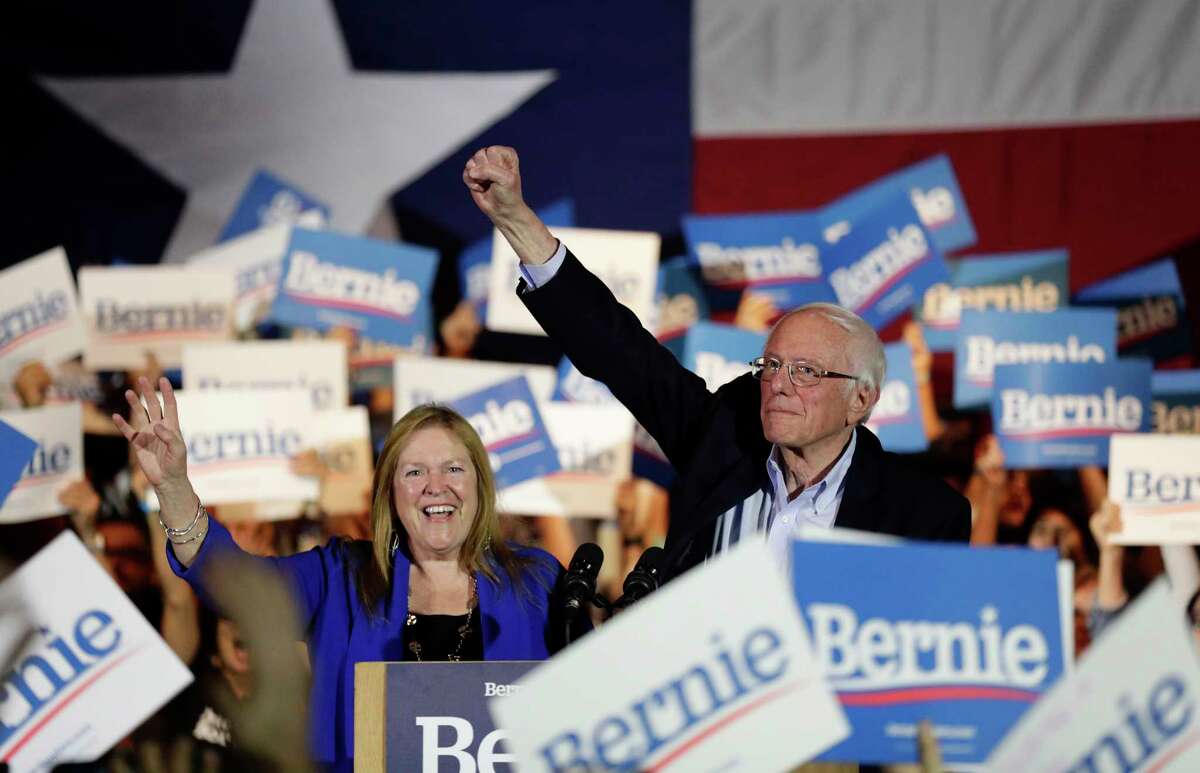 Democratic presidential candidate Sen. Bernie Sanders, I-Vt., right, with his wife Jane, raises his hand as he speaks during a campaign event in San Antonio, Saturday, Feb. 22, 2020. (AP Photo/Eric Gay)