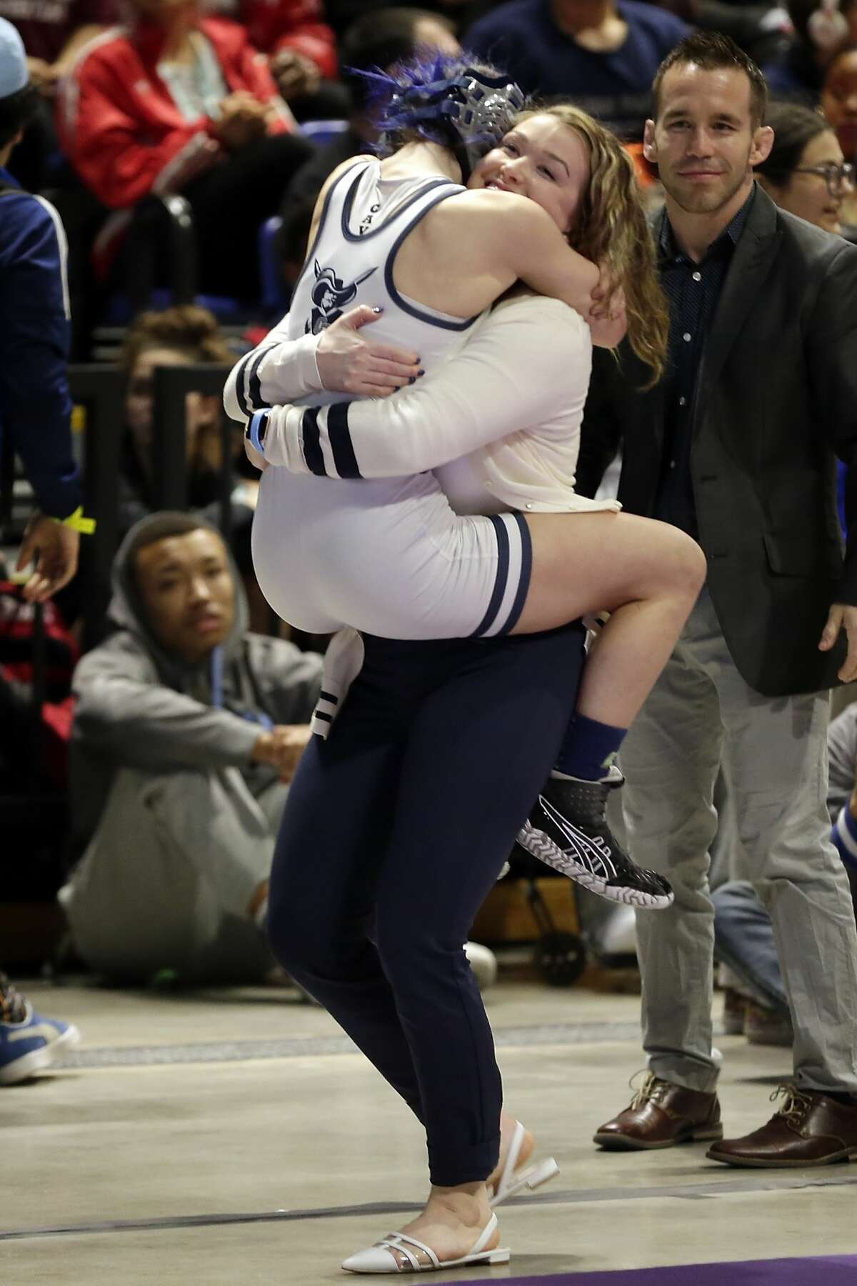 College Parks Olivia Degeorgio jumps into her coaches arms after defeating Tascosa's Mia Diaz in their Class 6A-95lbs championship match of the state high school wrestling championships Saturday, Feb. 22, 2020 at the Berry Center in Cypress, TX.